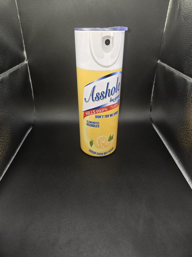 K&ouml;nnte beinhalten: Ein wei&szlig;-gelber Isolierbecher mit Deckel. Der Becher tr&auml;gt den Schriftzug "Asshole" in blauer Schrift sowie die S&auml;tze "Kills 99.9%", "Don't Try Me Spray" und "Eliminates Assholes". Au&szlig;erdem steht dort "Crisp Fuck Off Scent".
