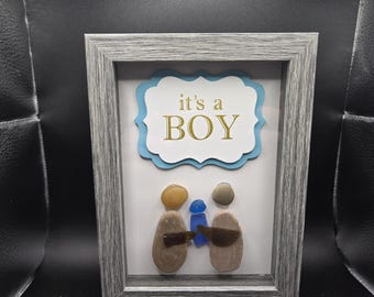 Es ist ein Junge Stein Menschen mit blauem Seeglas Baby Schattenkasten