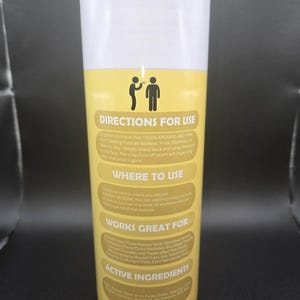 K&ouml;nnte beinhalten: Ein wei&szlig;er und gelber Becher mit dem Text "DIRECTIONS FOR USE" und "ASS HOLE BE GONE". Der Becher hat ein humorvolles Design mit Anweisungen und einer Liste der Wirkstoffe. Das Produkt ist ein Spray.