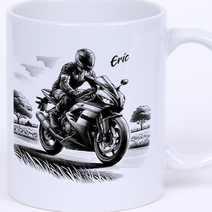 Puede incluir: Taza de cerámica blanca con una ilustración en blanco y negro de una motocicleta y un motociclista. La taza tiene un asa curva y el nombre "Eric" está impreso en el lateral. El diseño representa una motocicleta en una carretera con árboles y nubes en el fondo.