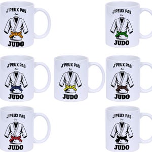 Peut inclure: Mugs blancs avec un thème Judo. Chaque mug présente un graphique d'uniforme de Judo avec une ceinture de couleur et le texte "J'PEUX PAS J'ai JUDO". Les ceintures sont jaunes, vertes, bleues, marron, rouges et noires.