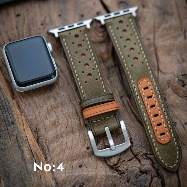 May include: Olive green leather watch strap with perforated detailing and tan accents. The strap features a silver buckle and is shown with a silver Apple Watch. The text "No:4" is visible in the lower left corner.