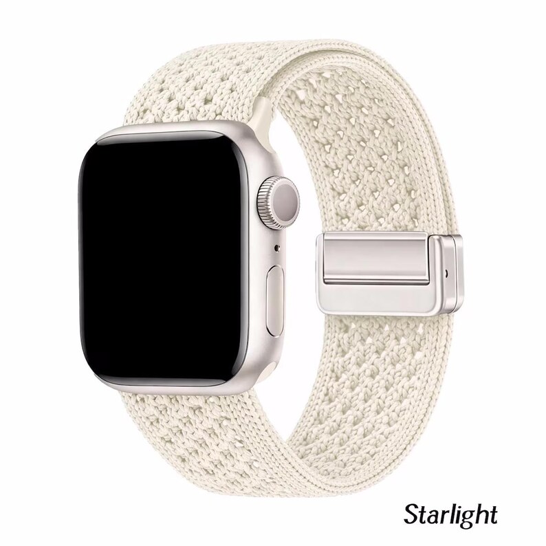 May include: A smartwatch with a rectangular silver case and a black screen, featuring a textured, off-white woven fabric band. The band includes a metallic silver clasp mechanism. The word Starlight is printed in black text below the watch.