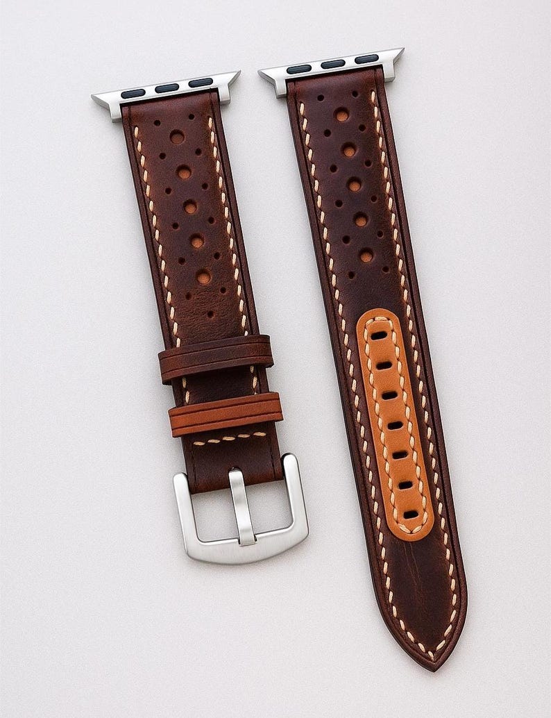 May include: Brown leather watch band with a perforated design and white stitching. The band features a silver buckle and a light brown accent piece. The text "No:1" is visible in the bottom right corner. The watch band is designed for an Apple Watch.
