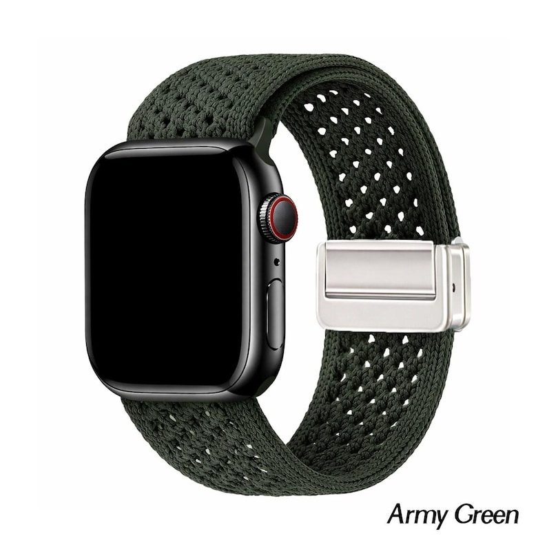 May include: A black smartwatch with a dark screen and a red ring on the side button, featuring an army green woven nylon watch band with a silver-toned metal magnetic clasp. The band has a textured, perforated pattern throughout its length.
