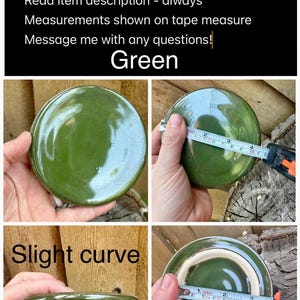 May include: A round, green ceramic lid with a glossy finish and a slight curve. A white measuring tape shows the lid has a diameter of approximately 3.5 inches. The lid features a smooth, glazed surface and a light-colored, unglazed rim edge.