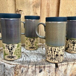 May include: Four tall ceramic mugs with black lids and handles. The upper sections have a smooth, dark grey glaze, while the lower sections feature intricate black line art of skeletal figures intertwined with tree branches on a light background.
