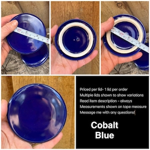 May include: A round, glossy cobalt blue ceramic lid with a smooth finish. A measuring tape placed across the top shows a diameter of approximately 3.5 inches. The underside features a white, unglazed circular rim for a secure fit.