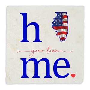 Puede incluir: Un letrero de decoración para el hogar azul y blanco con el texto "home" y "your town" en cursiva. El estado de Illinois está delineado en azul y relleno con un diseño de bandera estadounidense. Un pequeño corazón rojo se encuentra en la esquina inferior derecha.