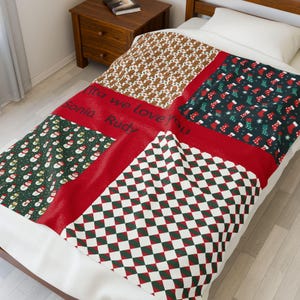 Peut inclure: Une couverture de Noël avec un motif patchwork. Elle présente des sections avec des bonhommes en pain d'épices, des bonhommes de neige, des bas de Noël et un motif à carreaux rouges et verts. Le texte "Rita we love you Sonia Rudy" est imprimé sur la couverture.
