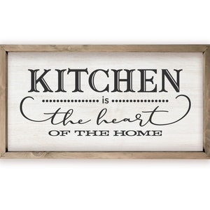 May include: A framed wooden sign with white background and black text that reads "Kitchen is the heart of the home".