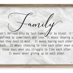 May include: A framed print with a white background and black text that reads "Family isn't defined only by last names or by blood: it's defined by commitment and love. It means showing up when they need it most. It means having each other's back. It means choosing to love each other even on those days when you struggle to like each other. It means never giving up on each other."