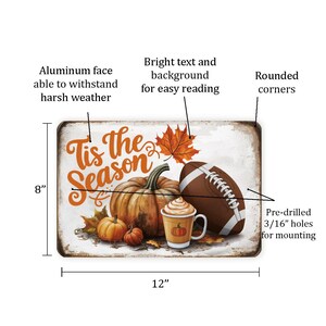 May include: A white metal sign with rounded corners featuring a fall-themed design. The sign reads "Tis the Season" in orange text with a pumpkin, football, and a cup of coffee. The sign is 12 inches wide and 8 inches tall.