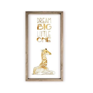 May include: A framed print with a watercolor illustration of a giraffe and the text "DREAM BIG LITTLE ONE" in gold lettering.