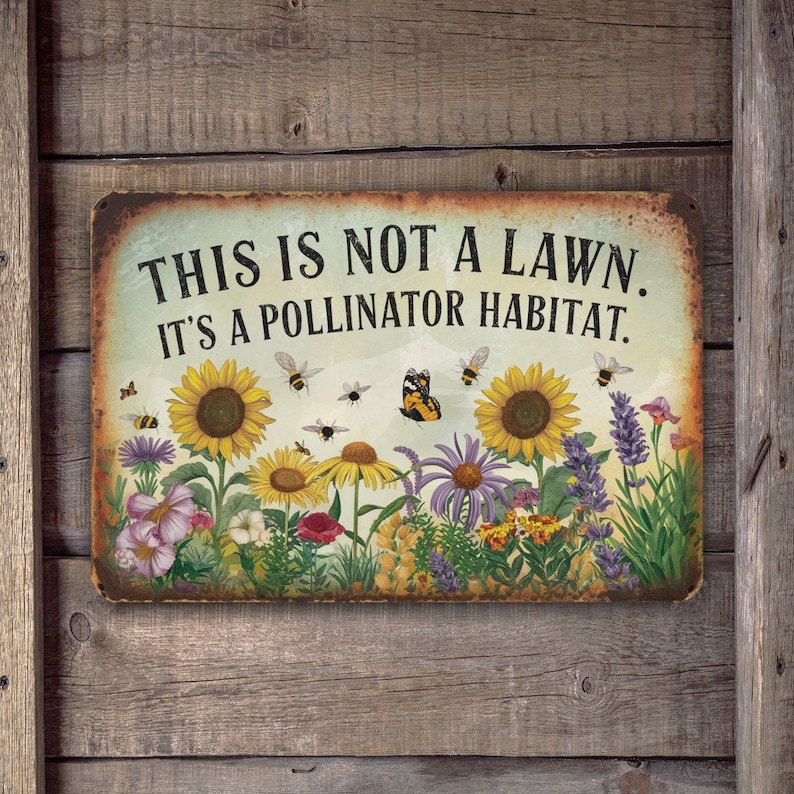 May include: A metal sign with a rustic background featuring a colorful garden scene with sunflowers, butterflies, and bees. The sign reads "This is not a lawn. It's a pollinator habitat."