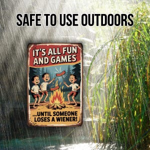 May include: A rectangular metal sign with the text "SAFE TO USE OUTDOORS" at the top. The sign features a cartoon illustration of three boys roasting hot dogs over a campfire, with the text "IT'S ALL FUN AND GAMES...UNTIL SOMEONE LOSES A WIENER!"