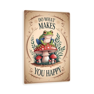 May include: A rectangular metal sign featuring a cartoon frog sitting on a red and white mushroom. The sign has the text "DO WHAT MAKES YOU HAPPY" in a decorative font, with a vintage-style border and floral accents.