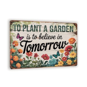 May include: A rectangular metal sign with the text "TO PLANT A GARDEN is to believe in Tomorrow." The sign features a floral border with orange, red, yellow, and blue flowers, and two butterflies. The background is a distressed white wood.