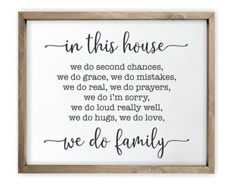 May include: A framed white sign with black text that reads "in this house we do second chances, we do grace, we do mistakes, we do real, we do prayers, we do I'm sorry, we do loud really well, we do hugs, we do love, we do family".