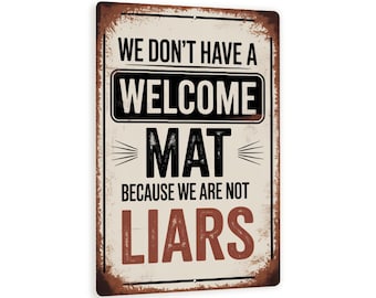 May include: Rectangular metal sign with a distressed, rusty appearance. The sign features the text "WE DON'T HAVE A WELCOME MAT BECAUSE WE ARE NOT LIARS" in black and brown lettering against a cream background.