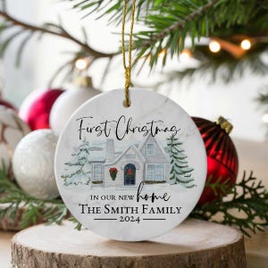May include: White ceramic Christmas ornament with a watercolor illustration of a house, trees, and the text "First Christmas in our new home The Smith Family 2024".
