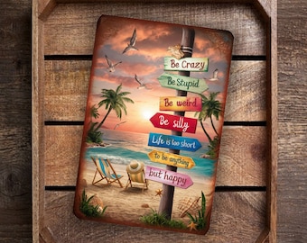 May include: A metal sign with a beach scene and a wooden post with colorful signs that read "Be Crazy", "Be Stupid", "Be Weird", "Be Silly", "Life is too short to be anything but happy".