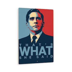 May include: Rectangular metal sign featuring a stylized portrait of a man in a suit, with a red and blue background. The text "THAT'S WHAT SHE SAID" is displayed in bold, blue letters.