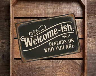May include: Black metal sign with white text that reads "Welcome-ish: Depends on who you are."