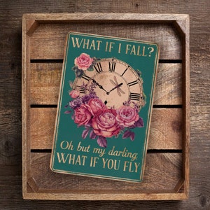 May include: A teal green sign with a vintage clock and pink roses. The sign reads "What if I fall? Oh but my darling what if you fly."