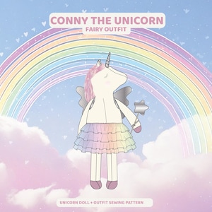 K&ouml;nnte beinhalten: Illustration einer Einhorn-Puppe in einem Feen-Outfit, vor einem Regenbogen und Wolken. Die Puppe hat eine rosa M&auml;hne, silberne Fl&uuml;gel und einen sternf&ouml;rmigen Zauberstab. Der Text oben lautet "Conny the Unicorn Fairy Outfit". Der Text unten lautet "Unicorn Doll + Outfit Sewing Pattern".