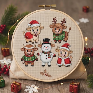 May include: A cross-stitch embroidery hoop featuring five festive bovine characters. The cows are dressed in holiday attire, including Santa hats and sweaters. A snowman is also featured. The embroidery is set against a neutral fabric background.
