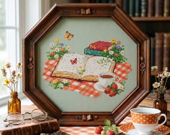 May include: A cross-stitch picture in a wooden frame, showing an open book with butterflies, flowers, and a coffee cup on a red and white checked cloth. The scene has a vintage feel. Strawberries and a teacup are in the foreground, creating a cosy atmosphere.