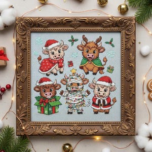 May include: A framed cross-stitch featuring five festive cows. Each cow is dressed in holiday attire, including Santa hats, capes, and wrapped in lights. The artwork is set against a light blue background with snowflakes and holiday accents, framed in a decorative gold frame.