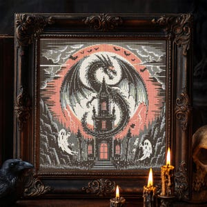 May include: Framed cross-stitch art featuring a dragon, castle, and ghosts against a pink and gray background. The dragon has large wings and is centered above the castle. The frame is dark brown with ornate detailing. The theme is gothic and spooky.