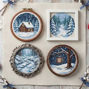 Può includere: Quattro opere d'arte a punto croce raffiguranti scene invernali. Una presenta una baita in una foresta innevata, incorniciata in un cerchio di legno. Un'altra mostra un sentiero innevato tra gli alberi, incorniciato in un quadrato bianco. Le altre due sono incorniciate in cerchi ornati d'argento e di legno.