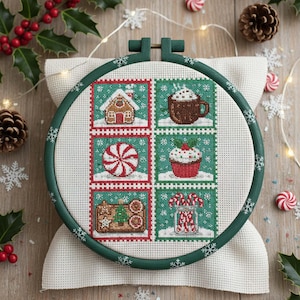 May include: A cross-stitch embroidery hoop featuring six festive Christmas-themed squares. The squares depict a gingerbread house, a mug of hot cocoa, a peppermint candy, a cupcake, a gingerbread cookie, and a jar of candy canes. The hoop is green with snowflake accents.