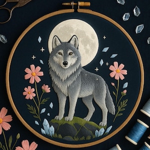 May include: Embroidered artwork featuring a gray wolf standing on a mossy rock, set against a dark blue background with a full moon. Pink flowers and blue crystals surround the wolf within a wooden embroidery hoop. The artwork is detailed and colorful.
