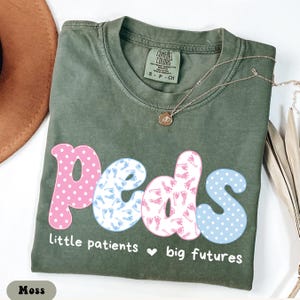 May include: A set of three ceramic mugs with a speckled, matte finish. The mugs are in shades of cream, light gray, and dark gray. Each mug has a simple, minimalist design, perfect for coffee or tea.