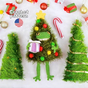 May include: A crochet pattern featuring a green frog dressed as a Christmas tree, adorned with small colorful pom-poms and a yellow star on top. The frog holds a small purple gift with a white ribbon. Two additional green crochet trees are included.
