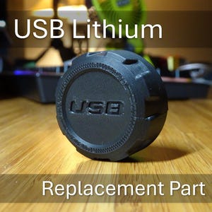 May include: A black USB Lithium replacement part with the word "USB" printed on it.