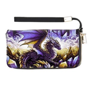May include: A black clutch wallet featuring a fantasy dragon design. The dragon is purple and gold, set against a background of crystals and clouds. The wallet has a black wrist strap and a zipper closure.