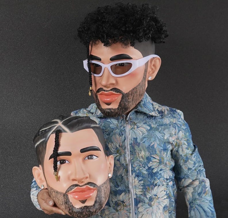 Op de afbeelding: Twee 3D-geprinte hoofden van een man met een baard en krullend haar. Het hoofd links houdt het hoofd rechts vast. Beide hoofden dragen een witte zonnebril.