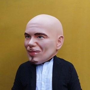 May include: A realistic latex mask of a bald man with a goatee. The mask is flesh-toned with brown eyes and a brown goatee.