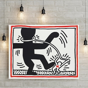 May include: A framed art print featuring a black and white graphic illustration with a red border. The artwork depicts a large figure with a rope around its neck, stepping on a smaller figure. Decorative light fixtures hang above.