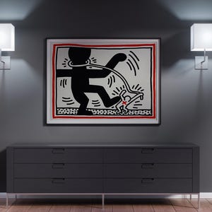 May include: A framed artwork featuring a black and white graphic of a figure with a leash, set against a red border. The artwork hangs above a dark gray dresser with six drawers, flanked by two square wall sconces.