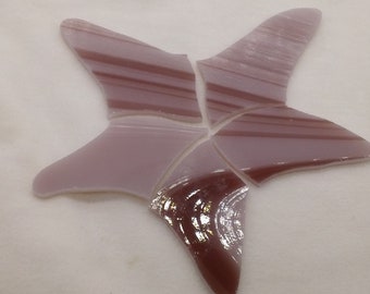 May include: A purple glass starfish with a striped pattern. The starfish is made of several pieces of glass that have been fused together.