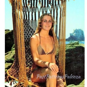 Puede incluir: Una mujer con un bikini de macramé a juego está sentada en un columpio de macramé hecho a mano. El columpio está suspendido de un marco de madera y adornado con cuentas de madera. El texto "Neptune's Throne" está en la parte inferior.
