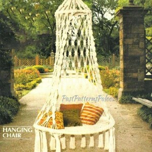 May include: A white macrame hanging chair with a round seat and decorative fringe. The chair is suspended from a canopy and has several throw pillows with orange, green, and yellow patterns. The words "HANGING CHAIR" are printed on the left side.