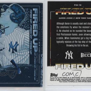 May include: A baseball card featuring Aaron Judge of the New York Yankees. The front of the card has a blue and white design with Judge in a pinstripe uniform. The words "FIRED UP" are prominently displayed. The back of the card has text about Judge.