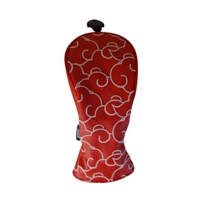 May include: Red golf club head cover with a white cloud pattern. The cover has a black pull cord and a small tag. The design is a repeating pattern of stylized clouds.